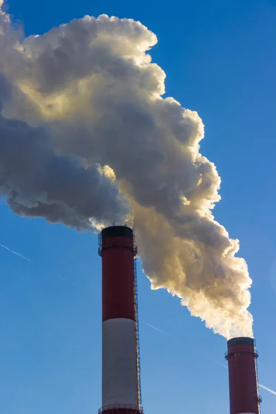 De pijp van de plant straalt schadelijke stoffen in de atmosfeer. Close-up op een hemelachtergrond — Stockfoto