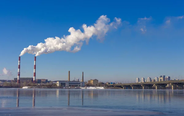 The pipe of the plant emits harmful substances into the atmosphere. Close-up on a sky background — Stock Photo, Image