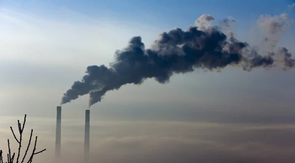 De pijp van de plant straalt schadelijke stoffen in de atmosfeer. Close-up op een hemelachtergrond — Stockfoto