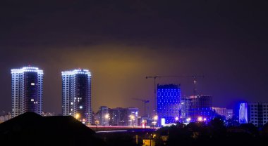 şehrin yukarısındaki gece gökyüzünde yıldırım