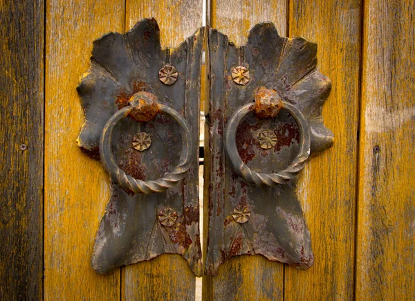 Door handle-knocker on the old wooden door