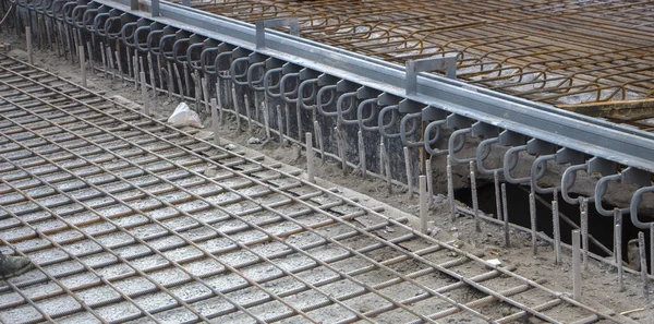 A grid of reinforcement laid on the surface ready for pouring concrete