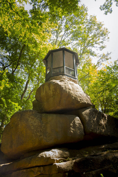 beautiful antique gazebo, on a huge boulder in the forest