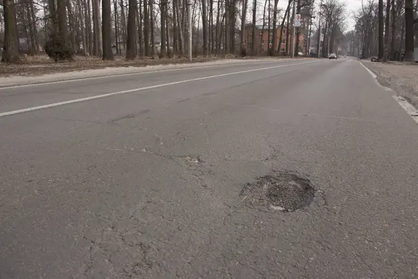 There are many potholes on the roadway close up — Stock Photo, Image