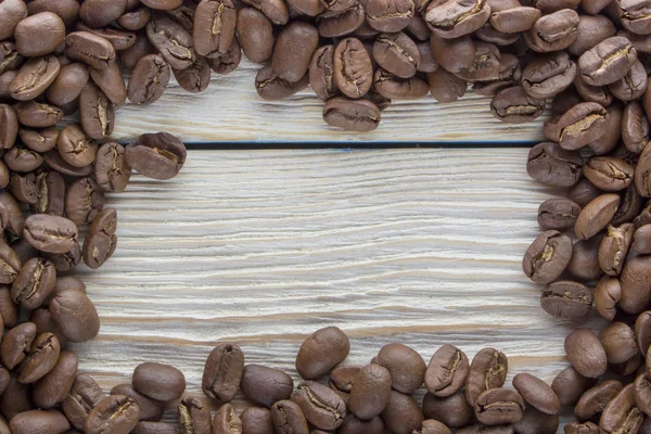 Grãos de café torrados na textura da madeira — Fotografia de Stock