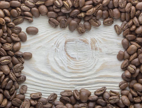 Жареные кофейные зерна на деревянной текстуре — стоковое фото