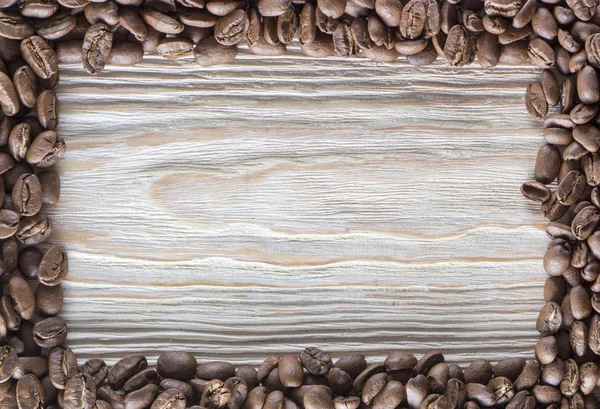 Grãos de café torrados na textura da madeira — Fotografia de Stock