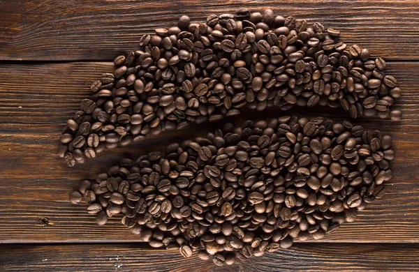 Жареные кофейные зерна на деревянной текстуре — стоковое фото