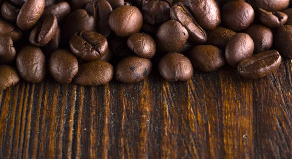 Granos de café tostados en textura de madera —  Fotos de Stock