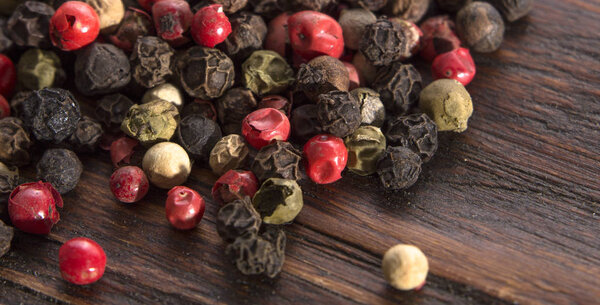 Смесь перца разных типов на винтажном деревянном фоне
