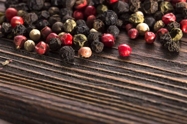 Směs pepřů různých typů na vinobraní dřevěné pozadí — Stock fotografie