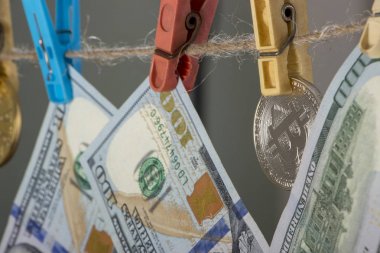 Para aklama kavramı. Sarı elbise peg Bitcoin ve yüz doları banknot tutun