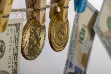 Para aklama kavramı. Sarı elbise peg Bitcoin ve yüz doları banknot tutun