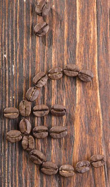 Signo de semillas de café sobre un fondo de madera — Foto de Stock