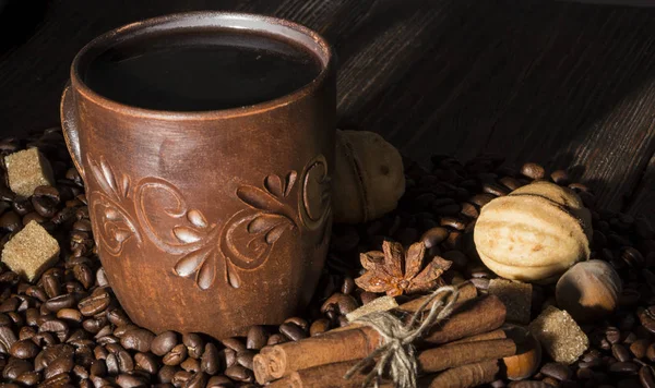 Xícara de barro com café no fundo de grãos — Fotografia de Stock