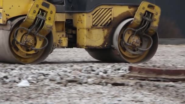 Rodillo rueda el suelo antes de instalar la losa de pavimentación — Vídeos de Stock