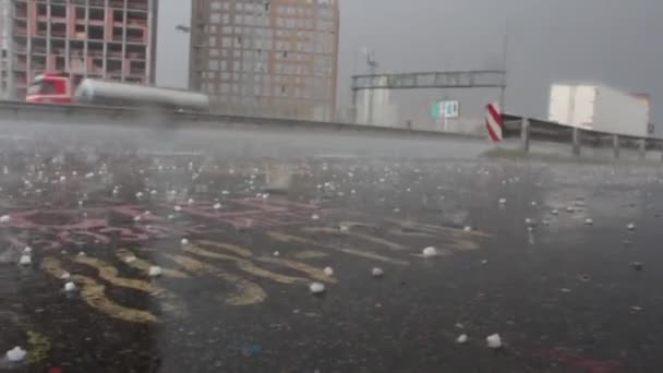 Vita hagelstenar studsar svart asfalt under en hagelstorm — Stockvideo