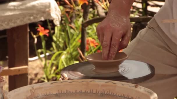 Töpfer arbeitet an einer Töpferscheibe, stellt Kaffeetassen her — Stockvideo