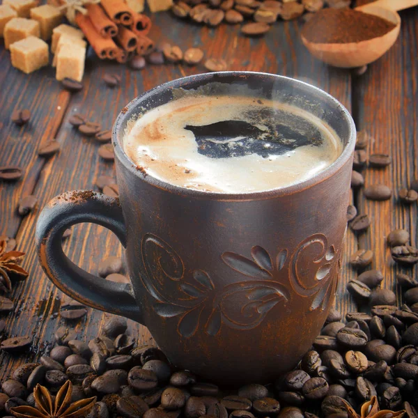 Tontasse mit Kaffee auf dem Hintergrund von Körnern — Stockfoto