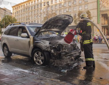 15 Temmuz 2015. Bağımsızlık Meydanı Kiev: Yangın bir arabaya sendikaların house yakınındaki bir salgının söndürür.