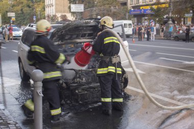 15 Temmuz 2015. Bağımsızlık Meydanı Kiev: Yangın bir arabaya sendikaların house yakınındaki bir salgının söndürür.