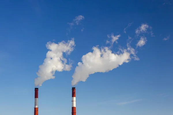 The pipe of the plant emits harmful substances into the atmosphere. Close-up on a sky background — Stock Photo, Image