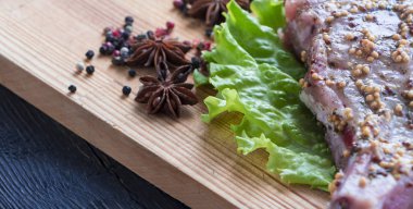 Seçici odak masada tüm malzemelerle bir biftek pişirme süreci