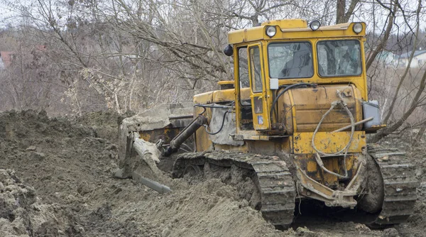 Un grande bulldozer scava un canale di bonifica — Foto Stock