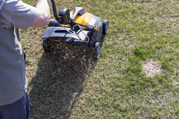 Máquina de aireación del suelo de funcionamiento del jardinero en césped de hierba — Foto de Stock