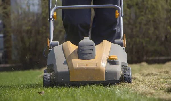 Jardinier faisant fonctionner la machine d'aération du sol sur la pelouse en herbe — Photo