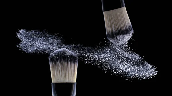 Понятие, макияж. Два мастера распыляют порошок на черном фоне . — стоковое фото