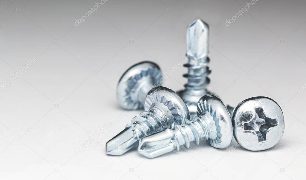 A few white self-tapping screws On a white background