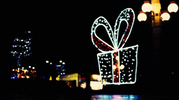 Defocus kerstverlichting op de straatboog met bloemenslingers in de vorm van een kerstbal. — Stockvideo