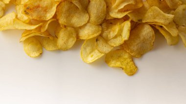 Beyaz arka planda altın rengi patates cipsi.