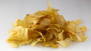Beyaz arka planda altın rengi patates cipsi.