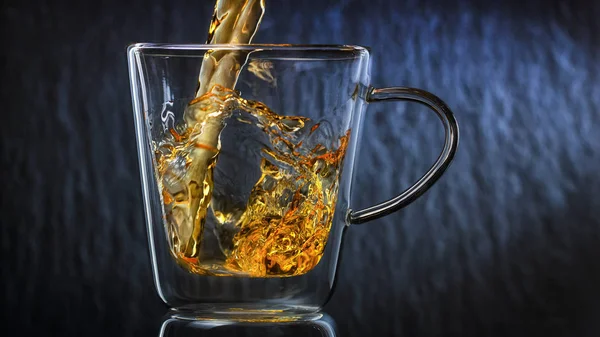 茶は暗い背景にガラスのカップに注がれます。 — ストック写真