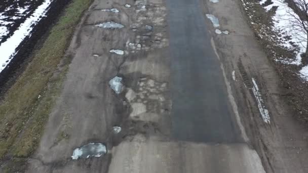 Λακκούβες Πολύ κακός δρόμος καλύπτεται πλήρως με ελαττώματα στην επιφάνεια, drone view — Αρχείο Βίντεο