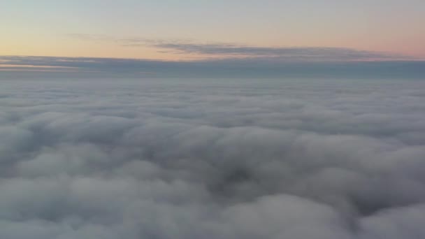 Nedsänkning i himlen flyger över morgonmolnen, kameran sjunker sakta ner i dimman — Stockvideo