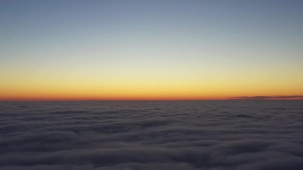 Nedsänkning i himlen flyger över morgonmolnen, kameran sjunker sakta ner i dimman — Stockvideo