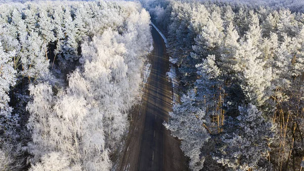 Luftaufnahme der Drohne für die Straße im winterlichen Nadelwald. — Stockfoto