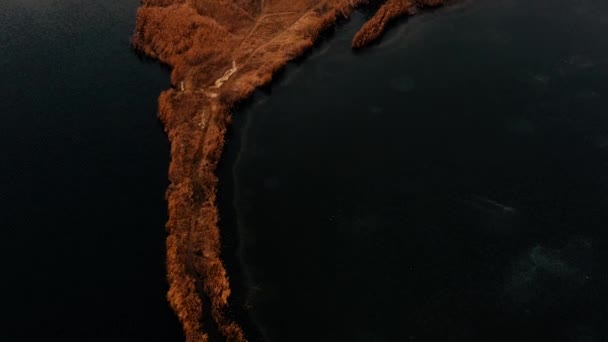 Noční let dronem nad ostrůvkem uprostřed zamrzlého jezera, podzimní krajina. — Stock video