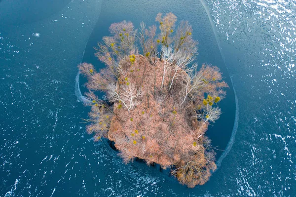 Mała wyspa w centrum zamarzniętego jeziora. Jesienny krajobraz. — Zdjęcie stockowe