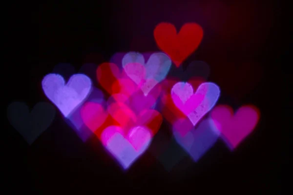 Colorful bokeh on a black background, in the form of heart — 图库照片