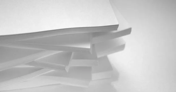 Varias pilas de papel blanco sobre un fondo blanco —  Fotos de Stock