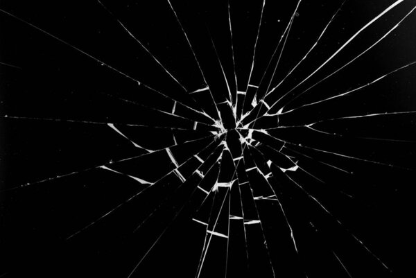 Round white cracks in glass on black background.