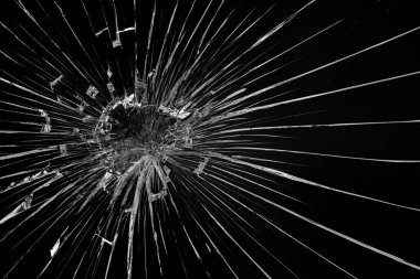 Siyah arka planda camda yuvarlak çatlaklar var. Merminin cam yüzeyindeki delik..