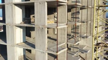 İnsansız hava aracının yavaş uçuşu, çok katlı beton bina inşaatı devam ediyor. Konut inşa kavramı.