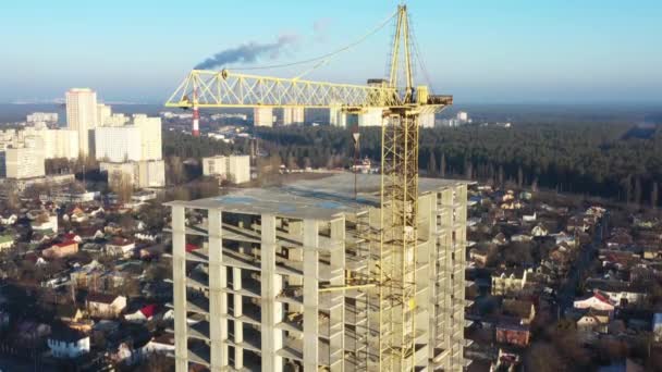 Bâtiment à étages, grue à tour et chantier de construction, vue sur le dessus. Au coucher du soleil .