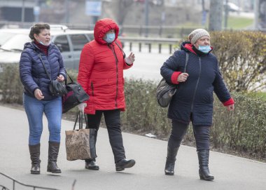 Ukrayna Kiev 23 Mart 2020: Üç yaşlı kadın karantina tedbirlerine uymadan Kiev 'de geziniyor. Uygunsuz giyimli maskeler SARS-CoV-2 veya COVID-19 koronavirüslerine karşı koruma sağlamaz..