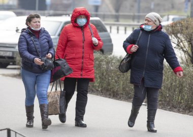 Ukrayna Kiev 23 Mart 2020: Üç yaşlı kadın karantina tedbirlerine uymadan Kiev 'de geziniyor. Uygunsuz giyimli maskeler SARS-CoV-2 veya COVID-19 koronavirüslerine karşı koruma sağlamaz..